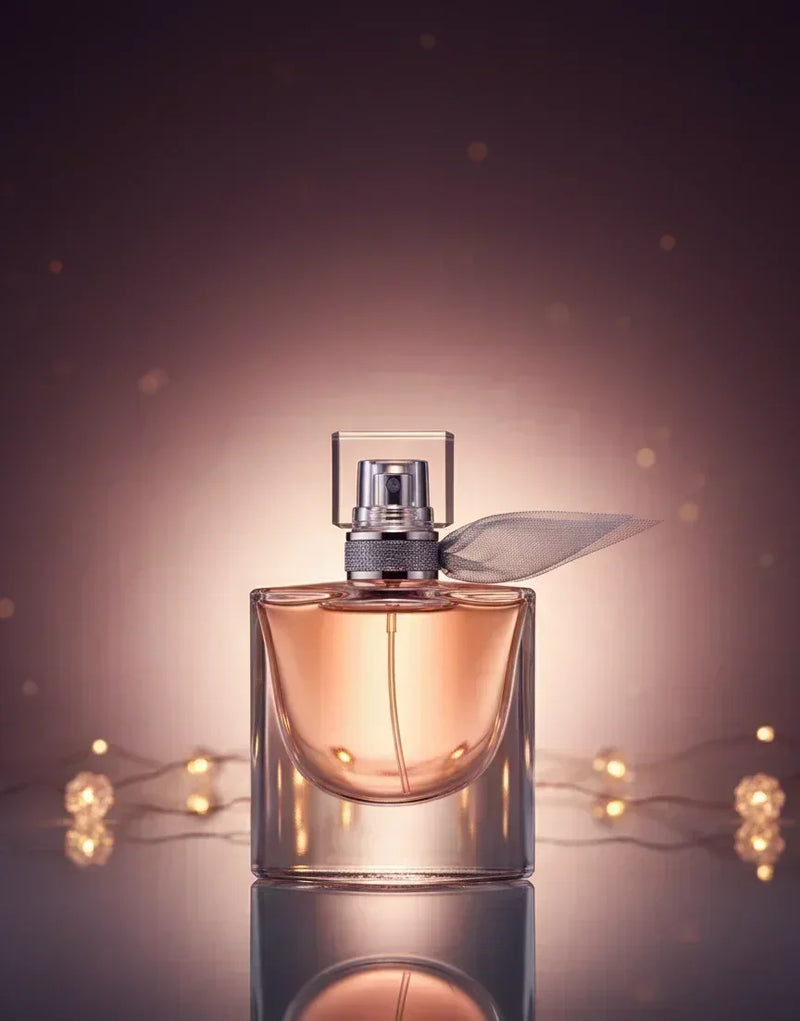 Frasco de perfume elegante com líquido âmbar, fundo com luzes douradas e brilho suave.